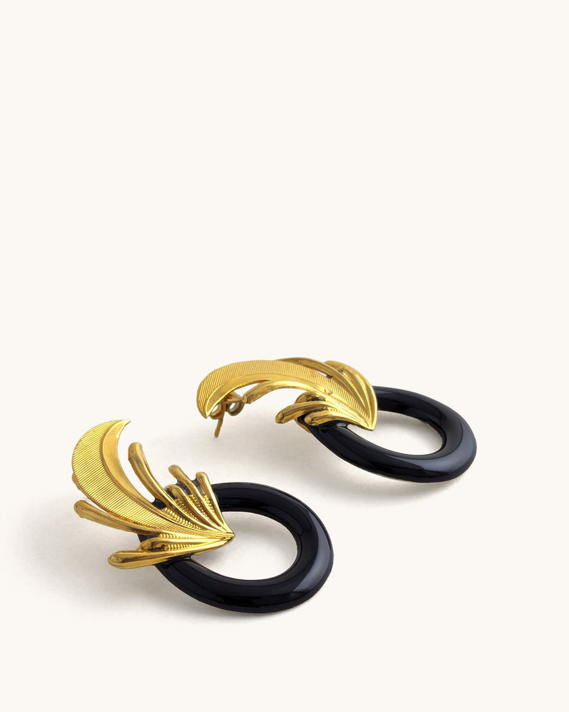 Boucles d’oreilles art déco noires et dorées, ornées d’un motif végétal sculpté rappelant l’élégance des années Gatsby, avec un anneau noir laqué contrastant. Créé par LYDIE SMITH artisan céramiste et bijoutier dans son atelier à Asnières en France