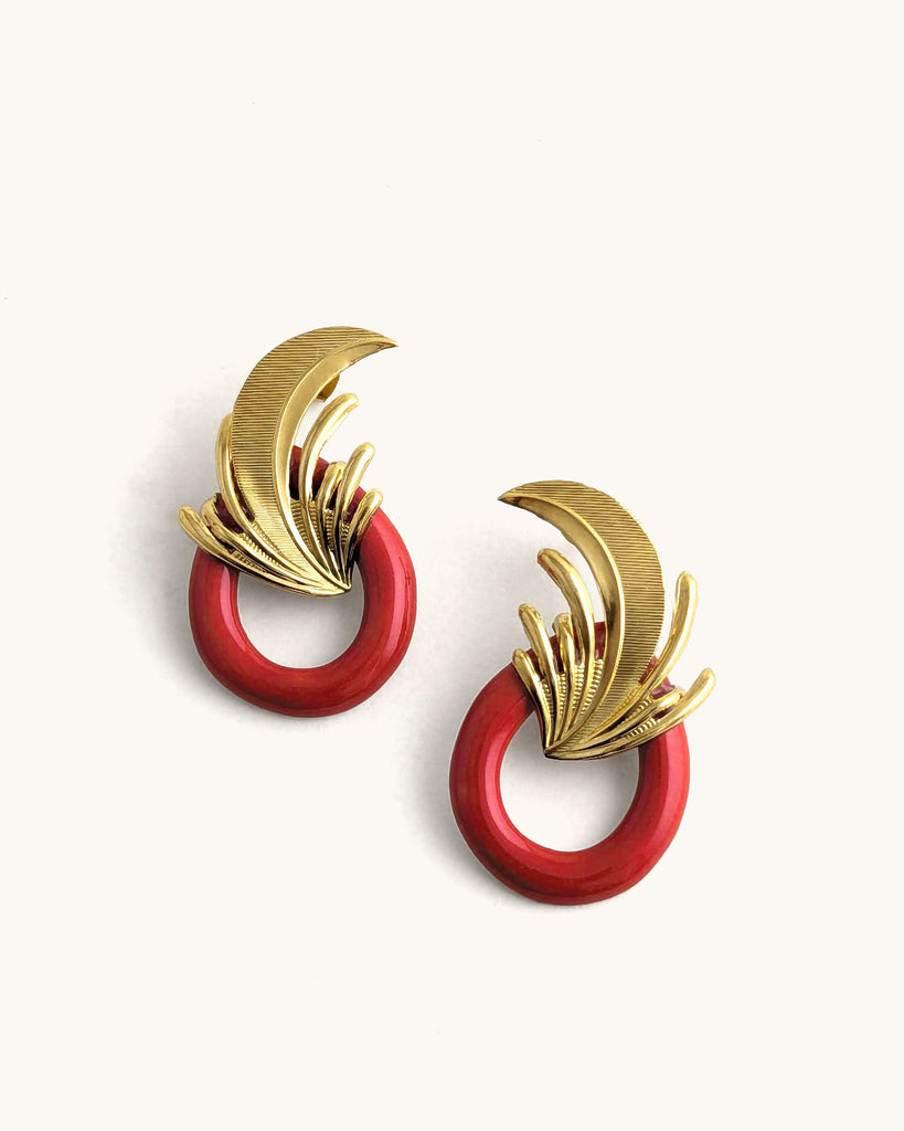 Boucles d’oreilles art déco rouge et or, ornées d’un motif végétal sculpté rappelant l’élégance des années Gatsby, avec un anneau noir laqué contrastant. Créé par LYDIE SMITH artisan céramiste et bijoutier dans son atelier à Asnières en France