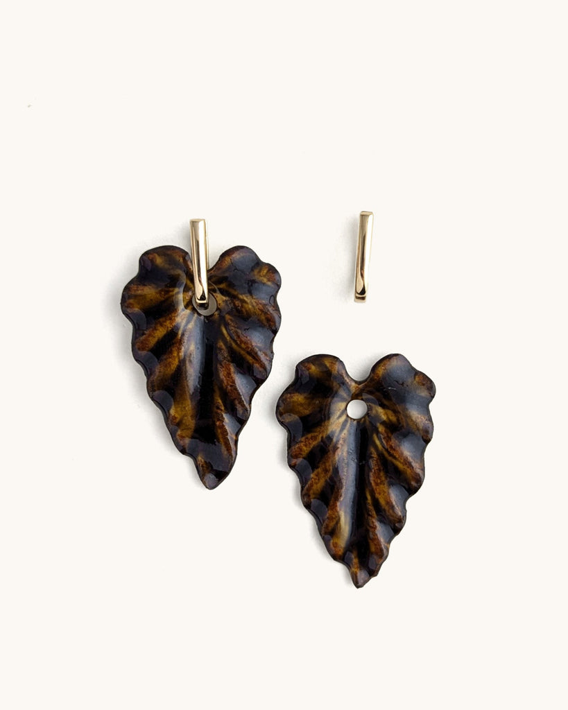Une feuille sculptée, un brun profond qui évoque la terre, l’écorce, le végétal transformé.
Ces boucles jouent la nature dans ce qu’elle a de plus intense : un volume vivant, texturé, façonné à la main.

Organique, expressive, inattendue — une présence qui réchauffe le visage et affirme le style. Nées de la beauté du végétal, ces boucles explorent les nuances de la botanique et la force silencieuse de ses formes.
Leur relief sculpté, leur lumière changeante et leur étonnante légèreté en font une pièce viva